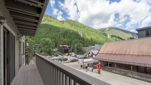 A balcony with a view of a parking lot, buildings, and a forested hill. - Luxury 3-Bedroom, Heart of Telluride, Mtn Views, 3 min walk to Gondola & Trails (Telluride)