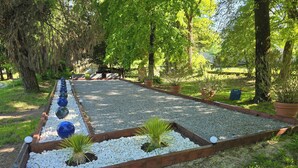 Un jardin avec un chemin de gravier, des bordures en bois et des plantes en pot.