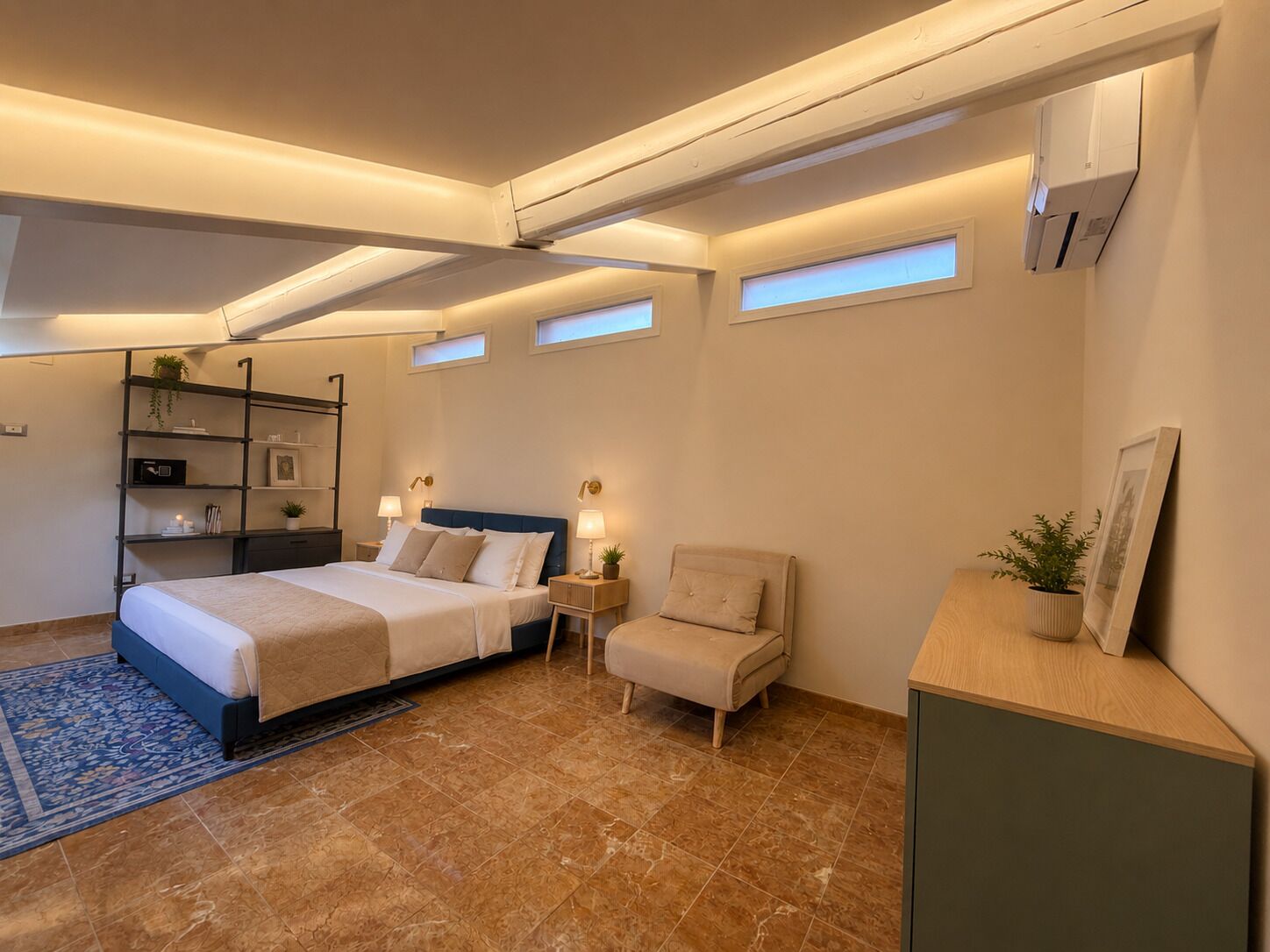 Une chambre à coucher avec un lit, des tables de chevet, une chaise, une étagère avec quelques objets et une petite plante.