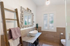 A bathroom with a wooden ladder, a white sink, and a mirror with a decorative frame. - Casa Vacanze Luce in Castelbianco – Tranquillity in Nature (Oresine)