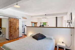 Ein Schlafzimmer mit einem Bett, einer Nachttischlampe und einer Holztür.