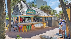 Eine Strandbar namens Marco Polo mit einem Reetdach, Außenbereich und einer Speisekarte.