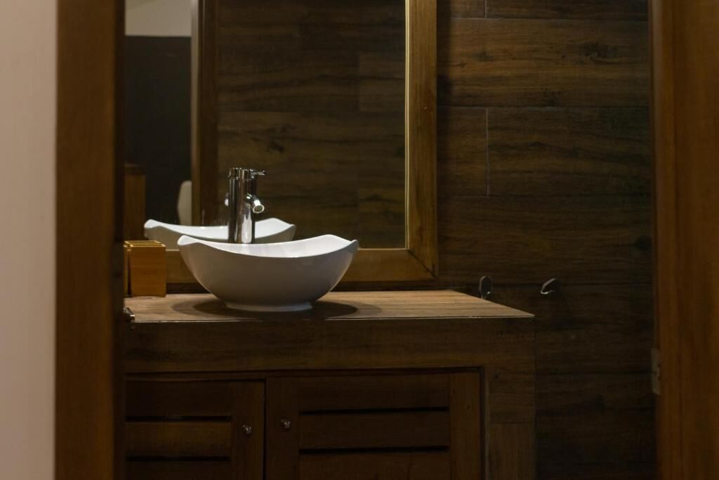 Une salle de bain avec un meuble-lavabo en bois, un lavabo blanc et un miroir.