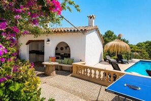 Eine Villa mit Pool, Sitzgelegenheit im Freien und einem Tischtennis-Tisch.