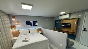 Ein Hotelzimmer mit Bett, Nachttischen, einer TV und einem Kleiderschrank.