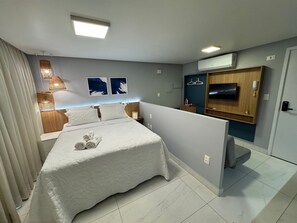 Une chambre d’hôtel avec un lit, des lampes de chevet, une télévision et une armoire.