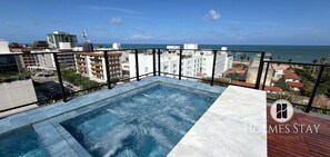 Ein Pool auf dem Dach mit Blick auf das Meer und die Stadtlandschaft.