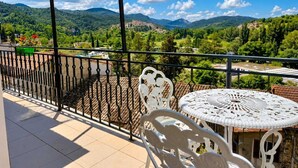 Ein Balkon mit Blick auf eine Berglandschaft, einem runden Tisch und einem Stuhl.