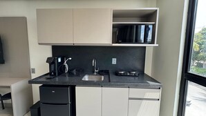 Uma cozinha moderna com máquina de lavar louça embutida, cafeteira e micro-ondas.