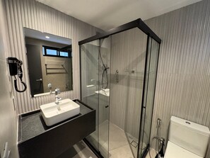 Ein modernes Badezimmer mit Waschtisch, Duschkabine und Toilette.
