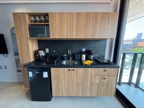 Una cocina moderna con microondas, cafetera y refrigerador.