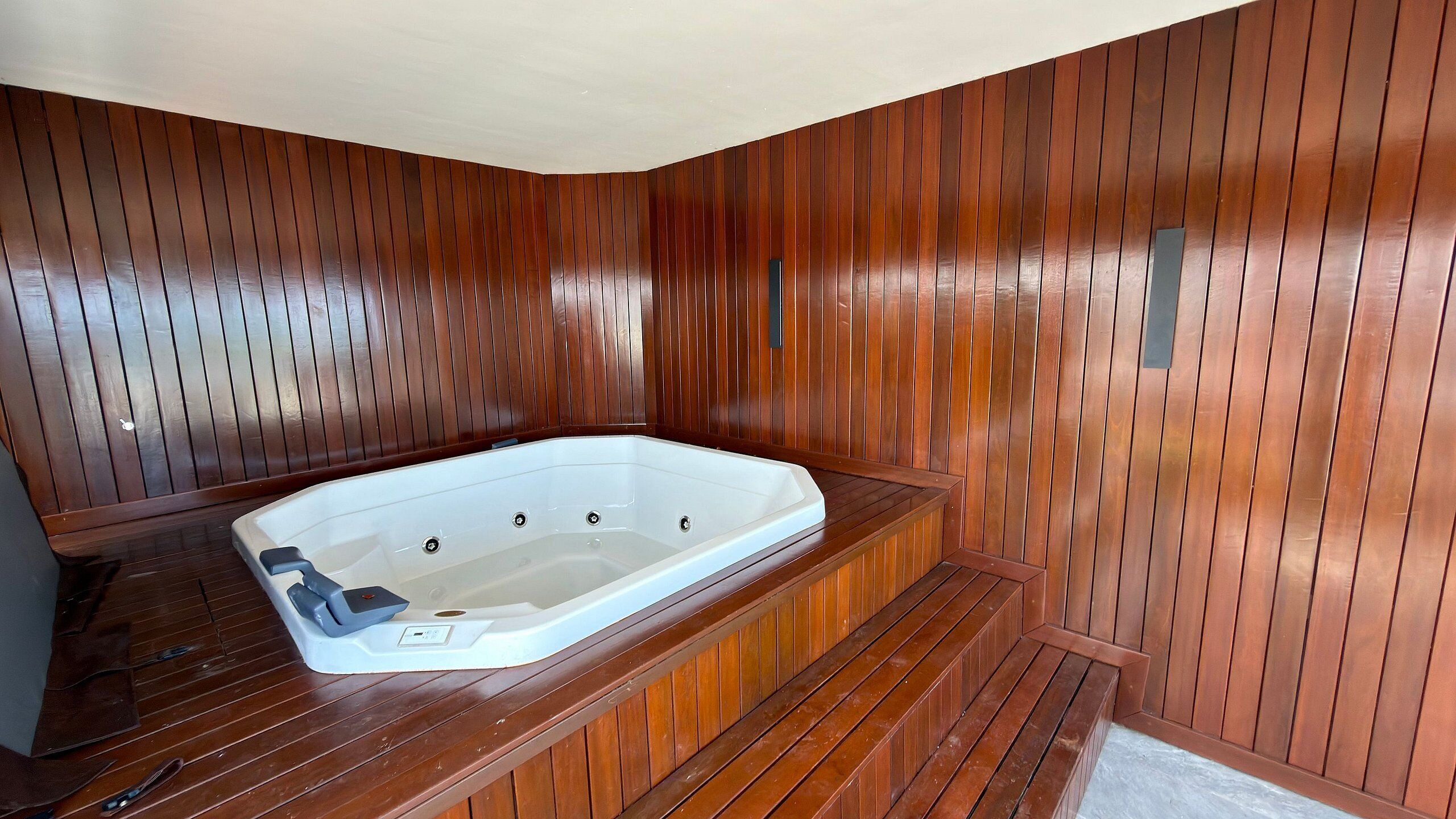 A wooden spa room with a hot tub.