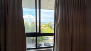 Ein Fenster mit Vorhängen, Blick auf eine Straße und ein Schild mit der Aufschrift 'E.GADOS RBANOS'.