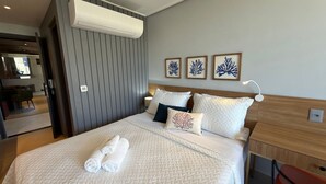 Una camera d'albergo con un letto, un comodino, una lampada e tre quadri appesi al muro.