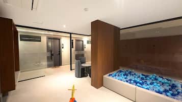 A modern interior with a play area, a large water feature, and a reception desk.