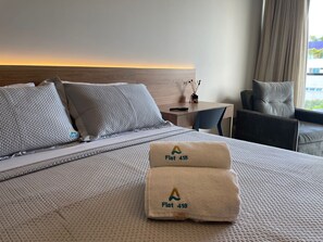 Una camera d'albergo con un letto, una scrivania, una sedia e vista sul tramonto.