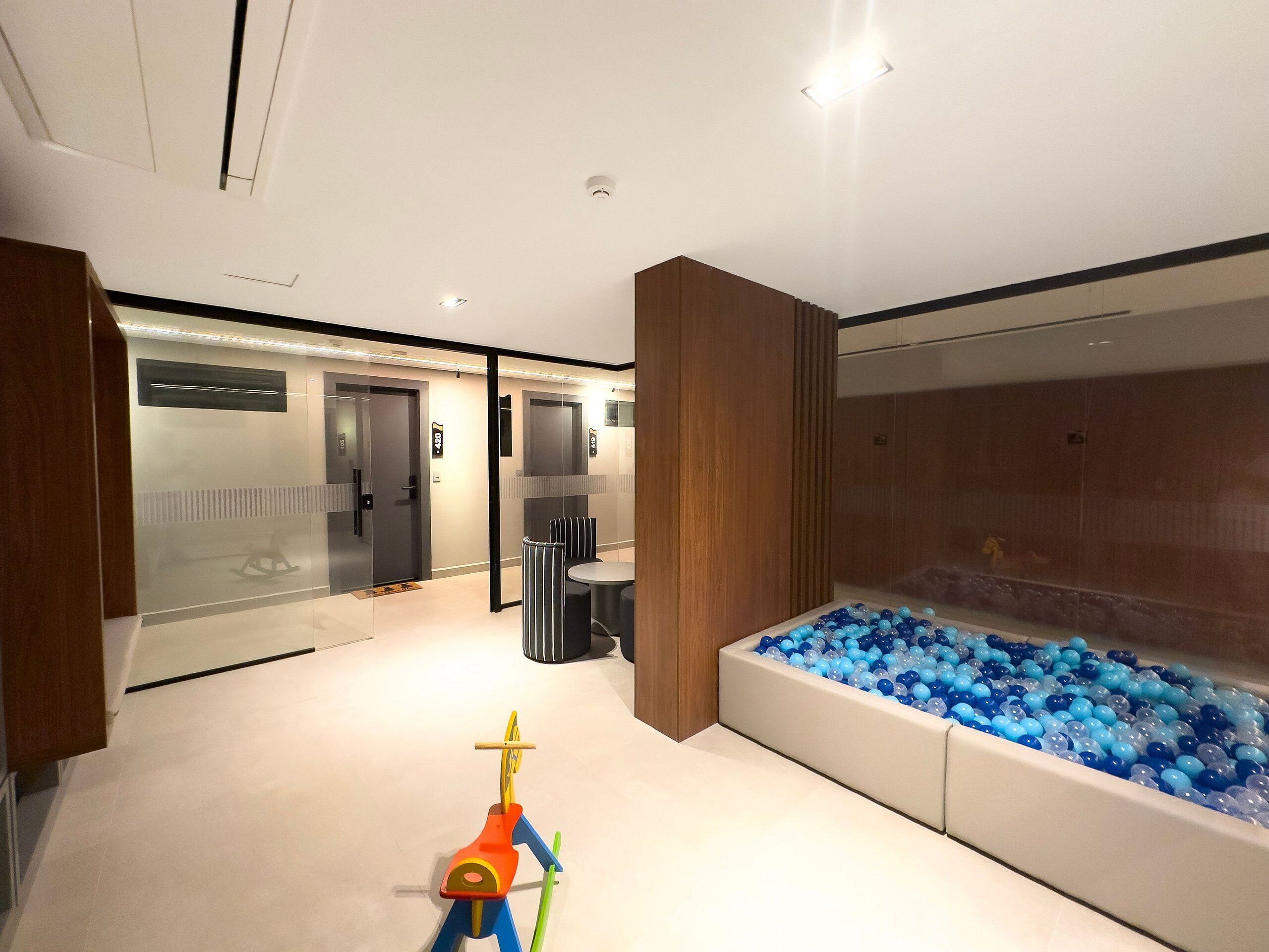 A modern interior with a play area, a large water feature, and a reception desk.