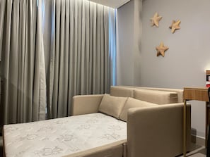 Ein Schlafzimmer mit einem Bett, einem Sessel und einer Wand mit Sternen-Dekorationen.