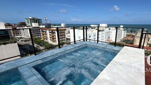 Ein Pool auf dem Dach mit Blick auf das Meer und die Stadtlandschaft.