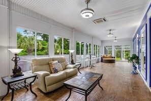 Ein geräumiges Zimmer mit einer Ledersofa, einem Couchtisch und einem Essbereich mit Stühlen.