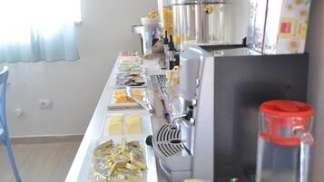 Una mesa de buffet con diversos alimentos y una máquina de café.
