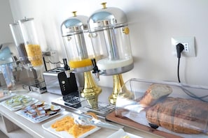 A breakfast buffet with coffee machines, a toaster, and a variety of food items. - Open Doors Bed & Breakfast  (Shkodër)