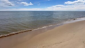 Una playa con cielo despejado y mar tranquilo.