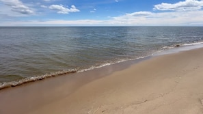 Une plage avec un ciel dégagé et une mer calme.