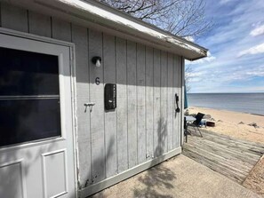 Un bâtiment en bois avec une porte, une boîte aux lettres et une vue sur la plage.