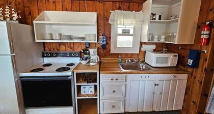 A 2-bedroom cottage with two queen beds, a dining area, and beach access steps away.