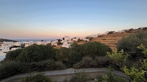 A coastal town with white buildings, a church with domes, and a hilly landscape. - #HH11 Guestroom for two in Katavati (Sifnos)