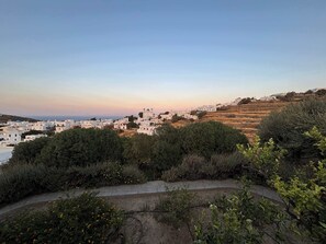 A coastal town with white buildings, a church with domes, and a hilly landscape. - #HH11 Guestroom for two in Katavati (Sifnos)