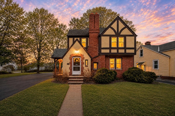 Charming Tudor-style home glowing warmly against a twilight sky.