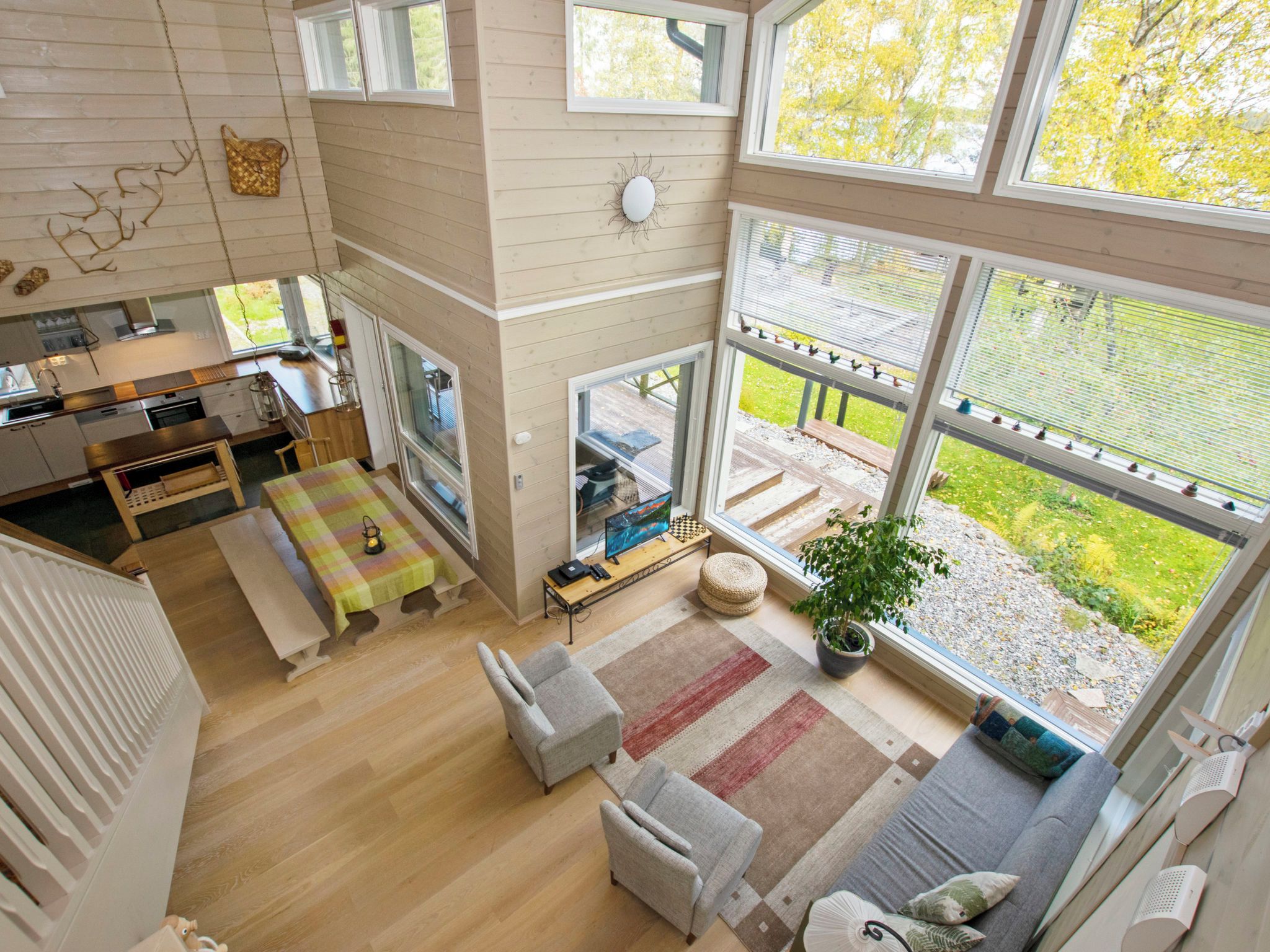 A spacious living area with a large window, a dining table, and a cozy seating arrangement.