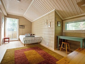 A room with a bed, a desk, a chair, a window, and a door. - Villa kuusiranta by Interhome (Kuopio)