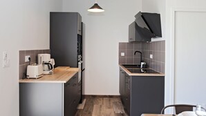 Una cocina compacta con cafetera, tostadora y pileta.