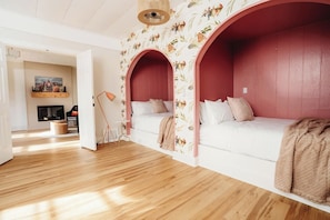 Una habitación con un sofá blanco, una pared roja y un papel tapiz estampado.