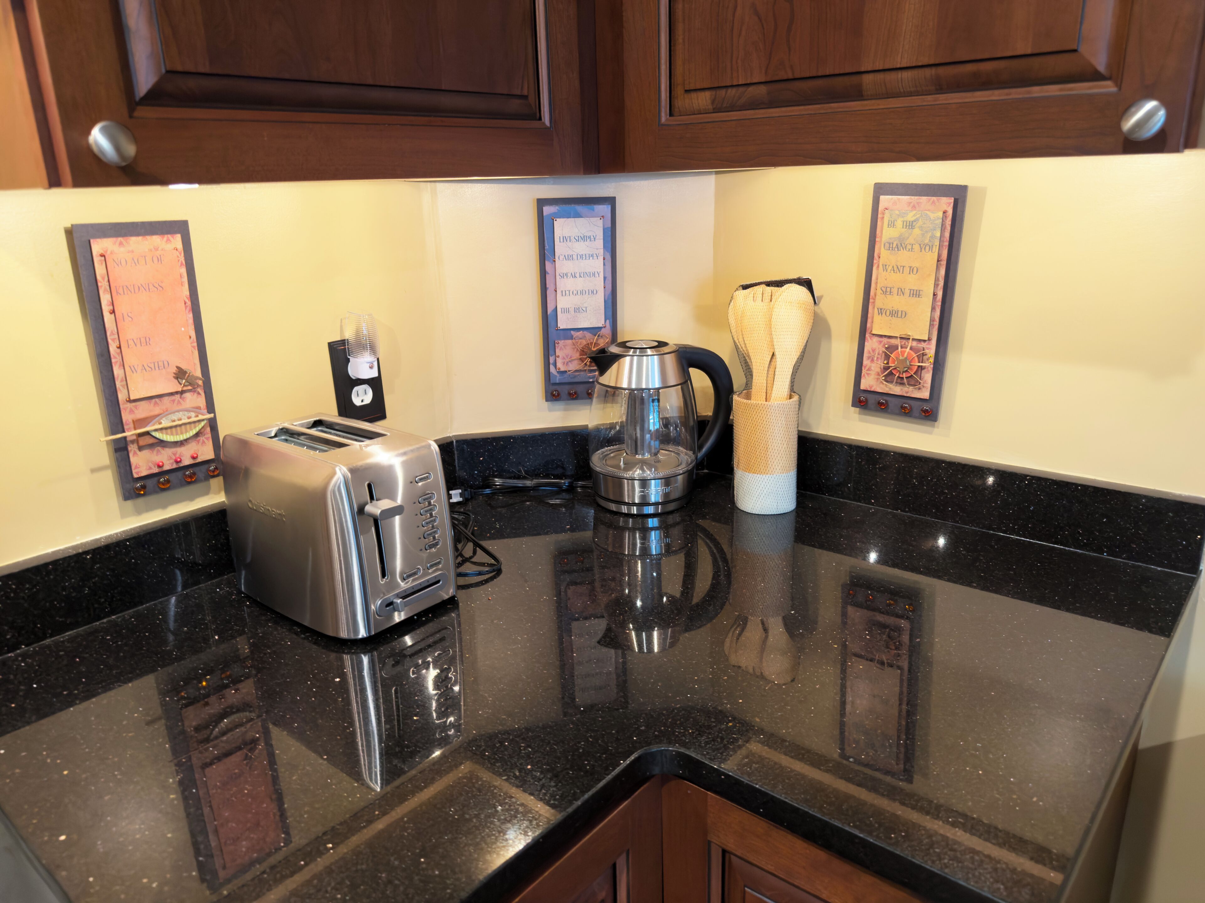 A kitchen with a toaster, a kettle, and a spice rack.