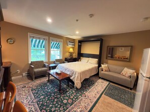 A hotel room with a bed, a sofa, a chair, a small table, and a window with a view. - Ogunquit Studio 2-Min Walk to Downtown (Ogunquit)