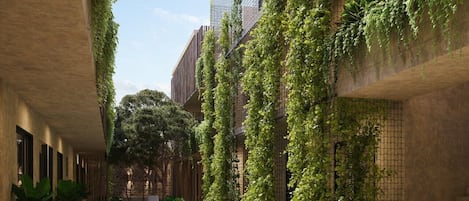 A modern building with a swimming pool, lounge chairs, and vertical gardens.