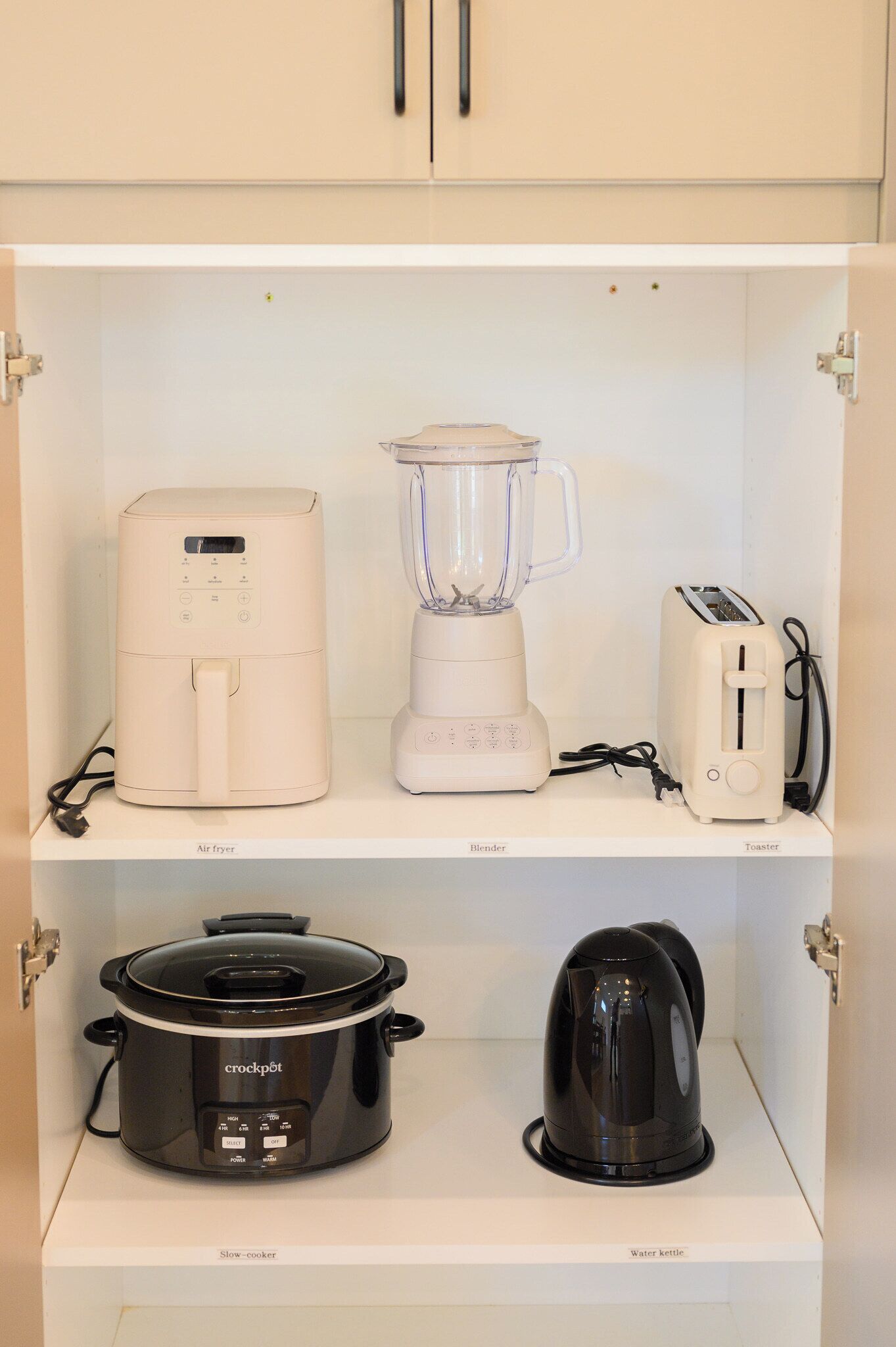 Una cucina che espone un friggitrice ad aria, un frullatore, un tostapane, una pentola a cottura lenta e un bollitore.