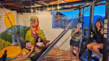 Una habitación con una hamaca, un mural y vistas a las montañas.