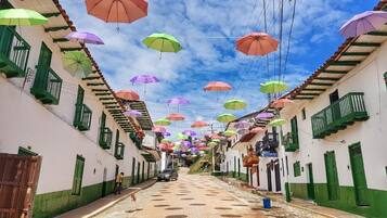 Una calle flanqueada por edificios, algunos con balcones, bajo un cielo despejado.