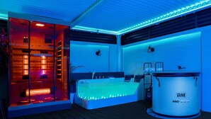Een kamer met een bed, een badkuip en een grote boiler.