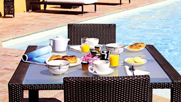 A poolside breakfast setup with lounge chairs, a table with breakfast items, and a pool. - Golf-side Holiday Home in Mazamet (Roquebrune-sur-Argens)