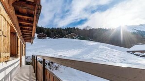 A wooden building with a balcony overlooking a snowy landscape. - Appt expo Sud 75 m2 - 1 séance SPA & Sauna - 3 Ch. (La Clusaz)