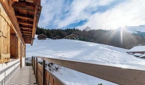 A wooden building with a balcony overlooking a snowy landscape. - Appt expo Sud 75 m2 - 1 séance SPA & Sauna - 3 Ch. (La Clusaz)
