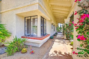 A covered outdoor area with a concrete floor, potted plants, and a cactus sculpture. - SRC301 Cozy 3BR Santa Rosa Cove Condo near Pool (La Quinta)