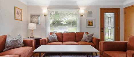 A living room with a sofa set, a coffee table, and a patterned rug.