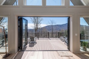 Eine Terrasse mit Blick auf Berge, einem Stuhl und einem Tisch.